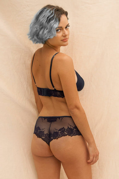 Jeune femme de dos, aux cheveux bleus portant un jolie ensemble de lingerie de la marque éthique Olly. 