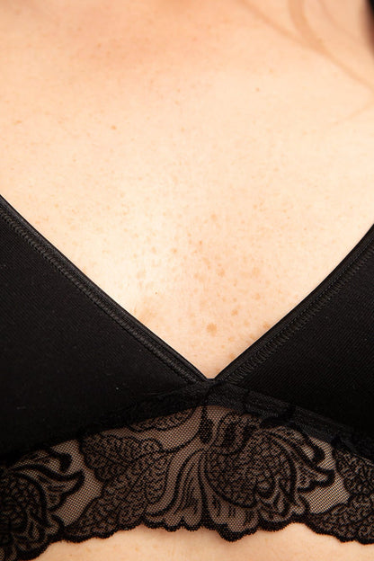 Décolleté d'une femme portant un soutien gorge triangle en coton avec une dentelle en relief velours.