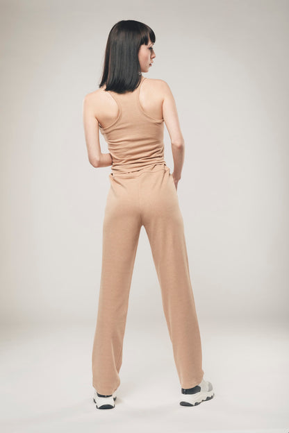 Image of back of light brown vegan trousers made by Organique, a sustainable clothing brand.