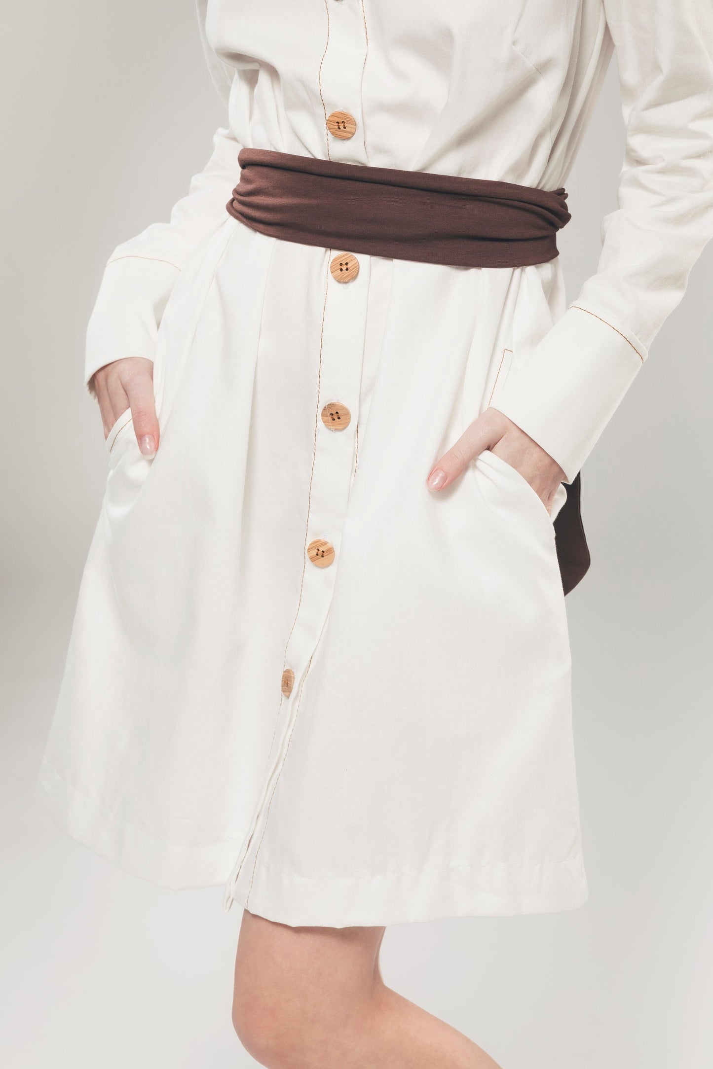 Imagem de detalhe de botão de vestido de camisa branca feita de algodão orgânico pela Organique.