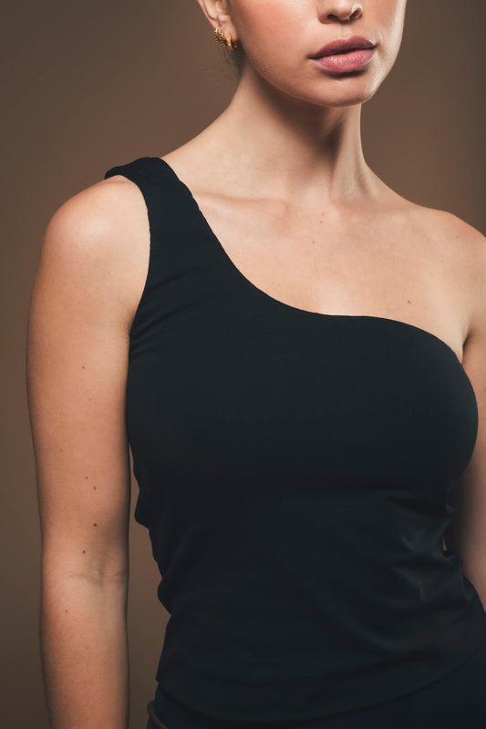 Image of details of black one shoulder top made by Organique, a sustainable clothing brand.